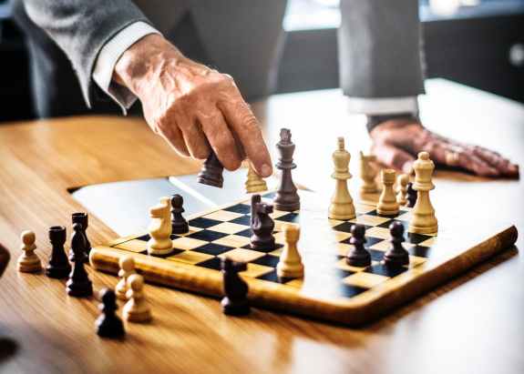 man in gray suit playing chess